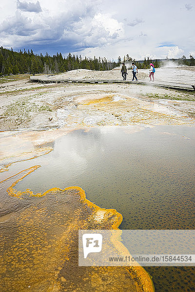 Drei Personen wandern im Upper Geyser Basin  Yellowstone-Nationalpark