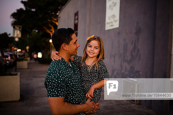 Vater betrachtet Tochter als Tochter lächelt für die Kamera