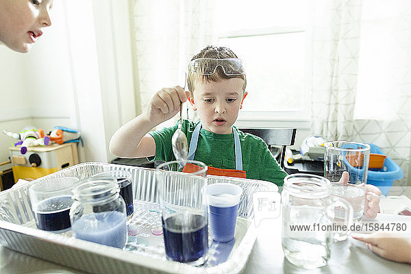 Junge im Grundschulalter  der zu Hause ein chemiewissenschaftliches Experiment macht