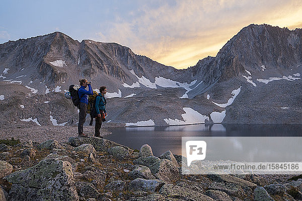 Women hikers watch sunset from Pierre Lakes  Elk Mountains  Colorado