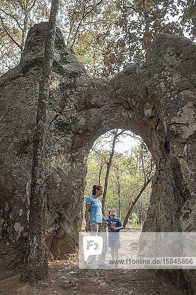 Mom and son under a natural arch in a rock at Huasca de Ocampo  Mexico