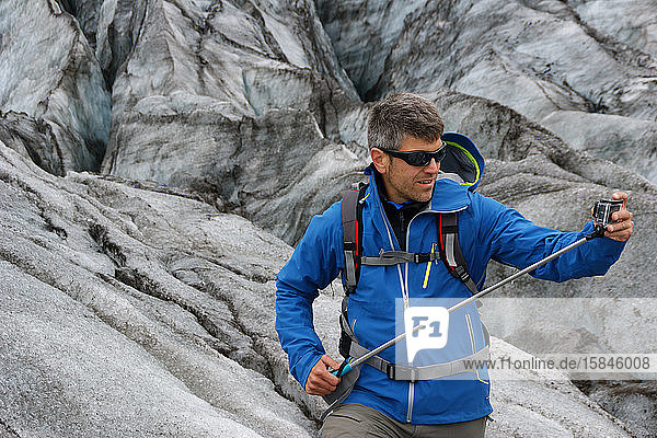 Ein Mann und eine Aktion mit einer Kamera auf dem Skaftafell-Gletscher in Vatnajokull