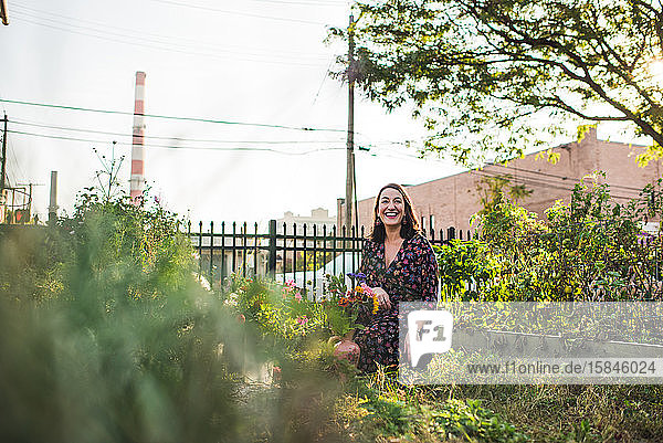 glückliche Frau  die in einem städtischen Garten arbeitet