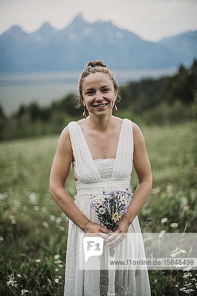 Braut hält Wildblumenstrauss in einem Blumenfeld  Wyoming