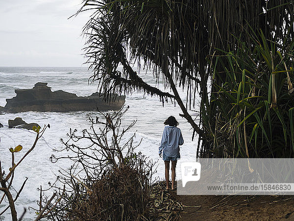Junge Frau beim Spaziergang an der Meeresküste