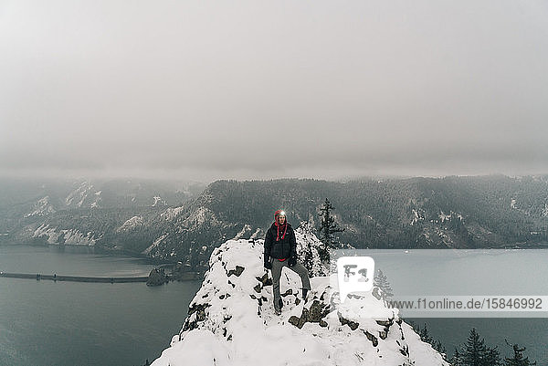 Eine junge Frau steht auf dem Gipfel eines verschneiten Punktes in der Columbia-Schlucht