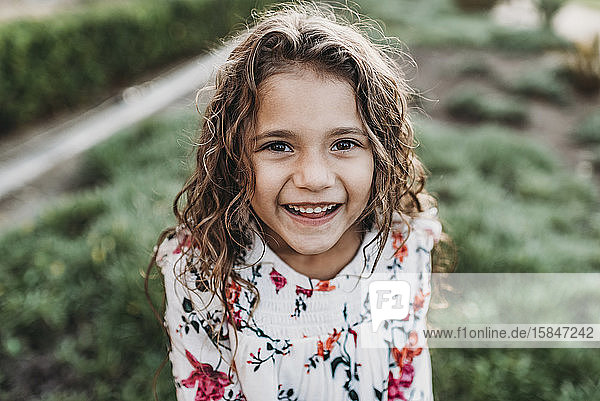 Close up portrait of young school-aged happy girl smiling at
