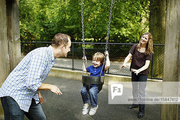 Family push son on swing