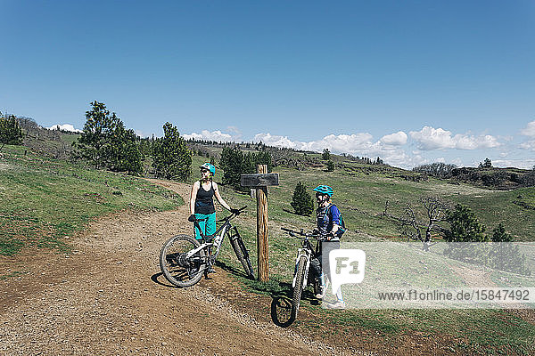 Two young women take a break while biking in Washington State.
