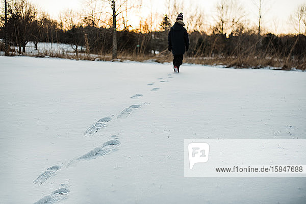 View of young boy's footprints in snow during Minnesota winter.