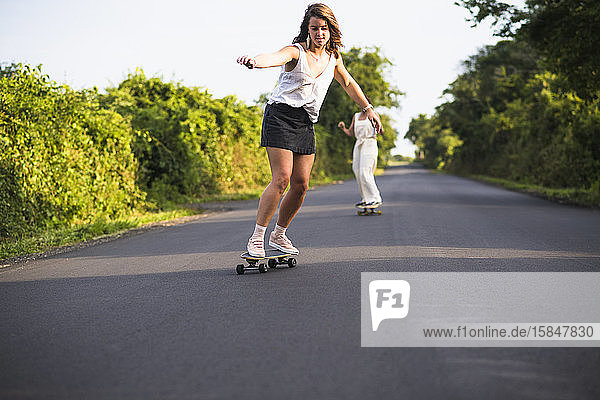 Junge Frauen beim Skateboarden im Sommer