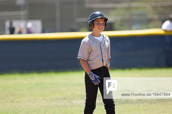 Little league player in baseball helmet smiling