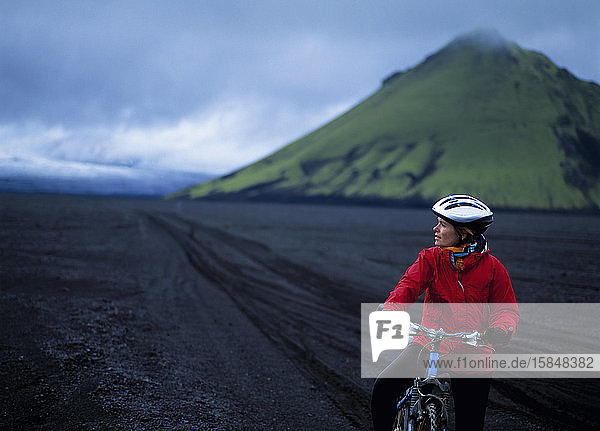 Radfahrende Frau auf Maelifellssandur im isländischen Hochland