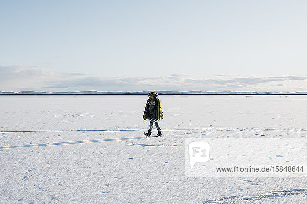 Junge geht allein in Schweden über einen zugefrorenen See