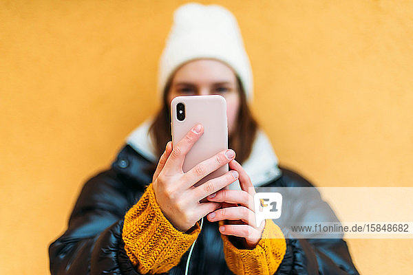 Junge attraktive Frau  die sich mit einem Smartpho fotografiert