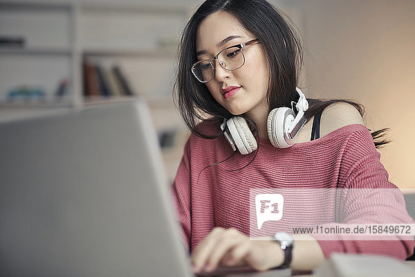 junge asiatische frau arbeitet mit laptop