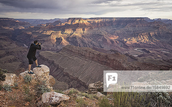 man photographing grand canyon at sunrise