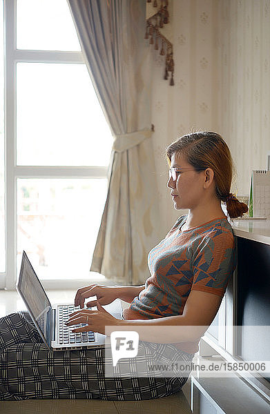 Frau benutzt Computer-Laptop für die Arbeit von zu Hause aus