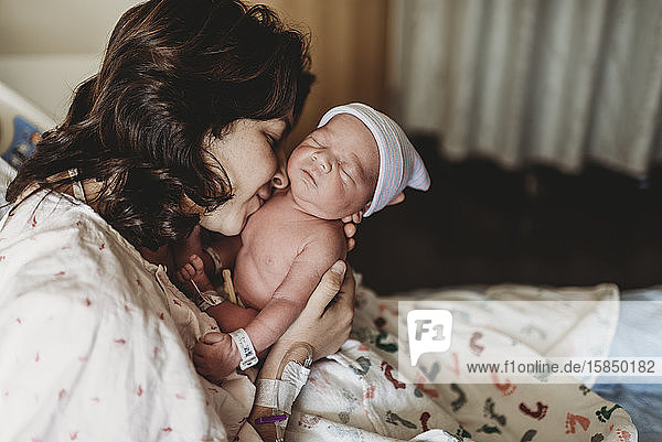 Detailaufnahme einer Mutter  die ihren neugeborenen Sohn im Krankenhaus küsst