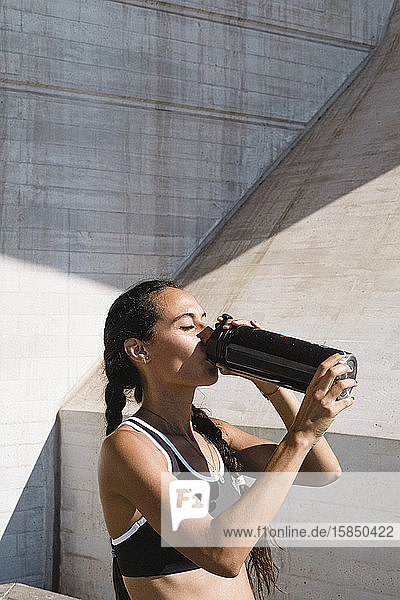Weibliche Sportlerin trinkt im Ruhezustand Wasser