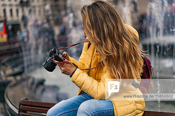 Junge Touristin mit Kamera beim Blick auf das Bild in der europäischen Altstadt.