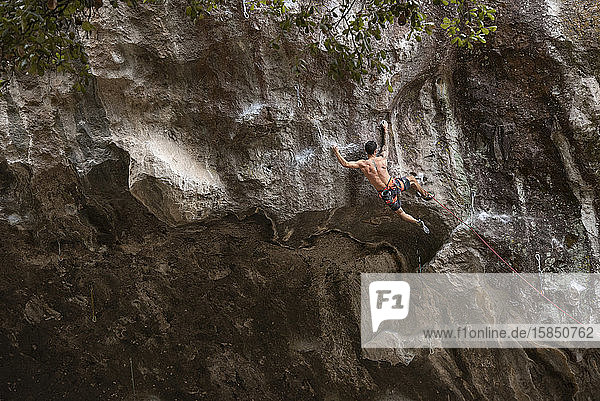 One tattooed man with no shirt rock climbing in Mexico