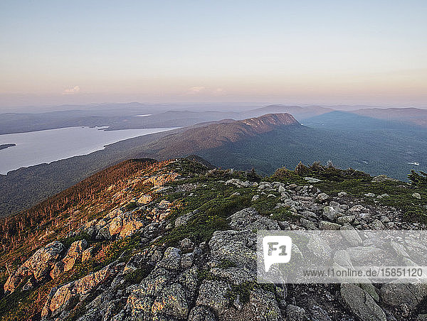 The sun sets on the Appalachian Trail over mountains and lakes  Maine.