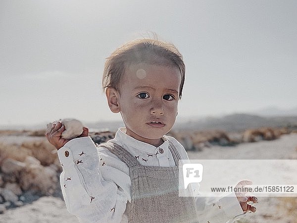Porträt eines Kindes  das in der Wüste in die Kamera schaut