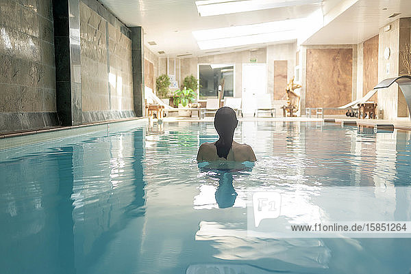 Rear view of a woman relaxing in spa pool