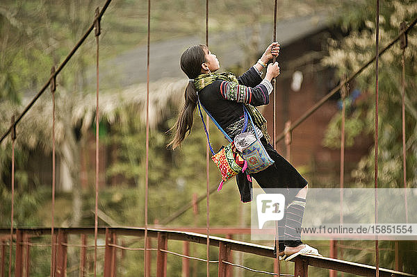 Hmong-Mädchen spielt auf der Dorfbrücke