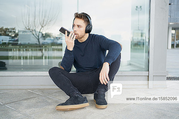 Young man with headphones on city street