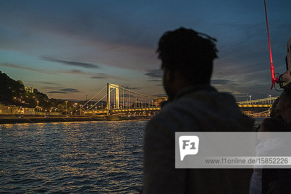 Afrikanischer Mann fotografiert nachts die beleuchtete Elisabeth-Brücke