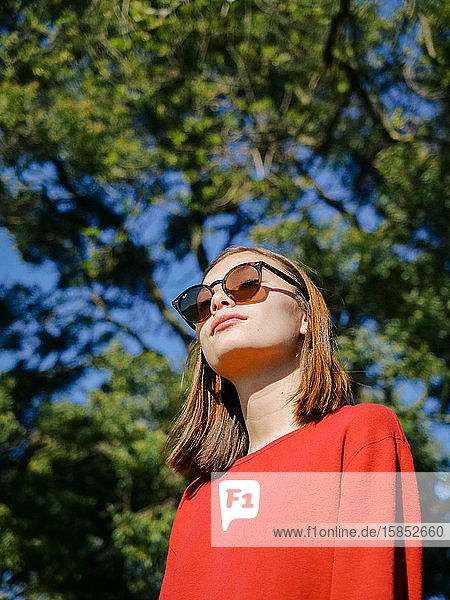 Nahaufnahme-Porträt eines eleganten jungen Mädchens  das draußen eine Sonnenbrille trägt