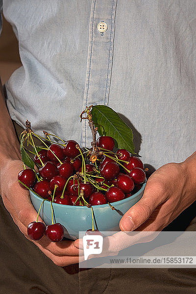 Blue cherry bowl held by a man's hands