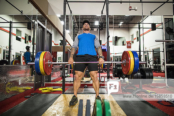 bodybuilder completes deadlift in the gym.