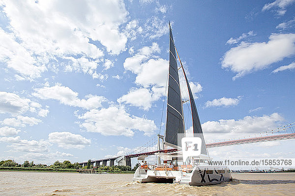 A catamaran cruising on the Garonne river Bordeaux Gironde France.