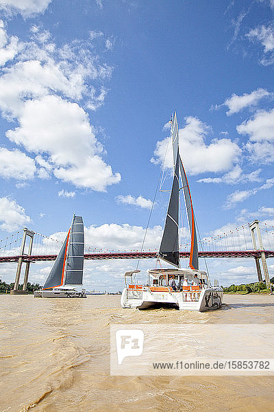 Two luxurious catamarans cruising on the Garonne river Bordeaux Gironde France.