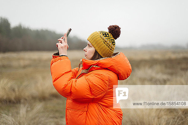 Junge Frau benutzt Smartphone im Freien
