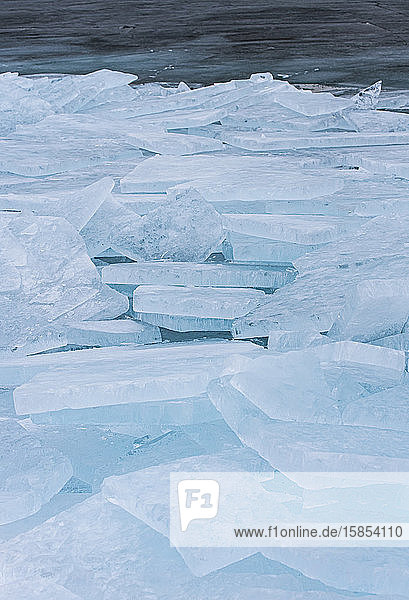 Große flache Eisstücke türmten sich im Winter entlang des Ufers eines Sees auf.