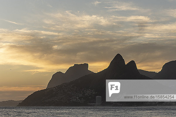 Beautiful sunset view to ocean with mountains and clouds from Ipanema