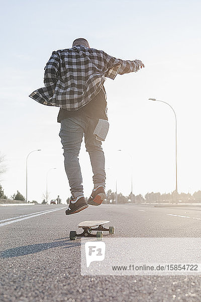 Junger Mann fährt Skateboard auf der Straße