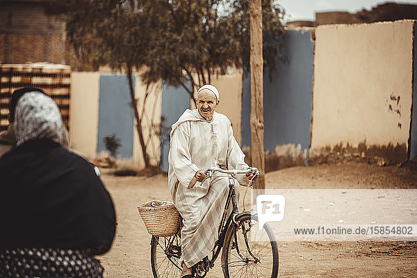 alter Mann mit Fahrrad auf der Straße