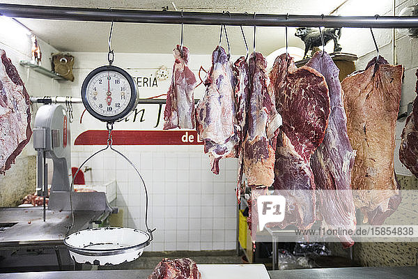 Fleisch und Schuppen hängen in der Auslage einer Marktschlachterei.