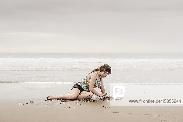 Young girl playing in the sand at the beach