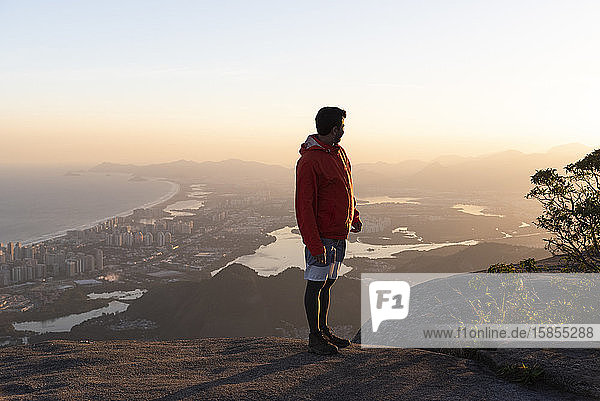 Beautiful landscape of man walking on mountain top with city on back