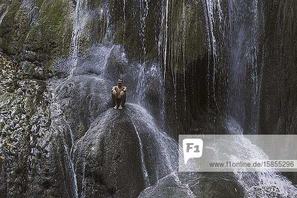 Mann klettert auf Wasserfall