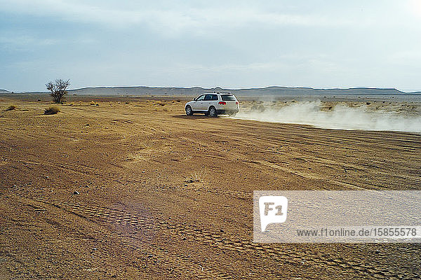 Ein 4x4-Auto mit hoher Geschwindigkeit durch die Wüste von Marokko
