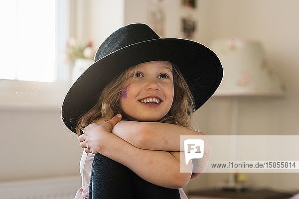 Porträt eines jungen Mädchens  das zu Hause lächelt und Verkleiden spielt