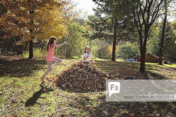 Drei junge Freunde spielen im Herbstlaub im Freien