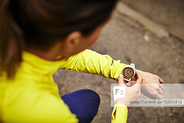 Eine Läuferin stellt ihre Fitness-Uhr.